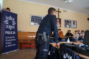 Na zdjęciu widzimy policjanta omawiającego z uczniami rekrutację do Policji