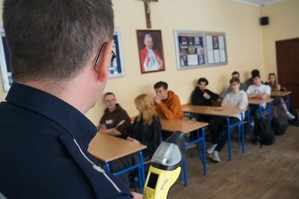 Na zdjęciu widzimy policjanta omawiającego z uczniami rekrutację do Policji