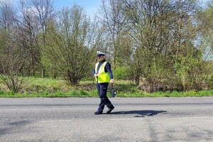 Na zdjęciu widzimy jak policjant zatrzymuje pojazd do kontroli