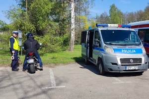 Na zdjęciu widzimy jak policjant przeprowadza kontrolę drogową z motocyklistą