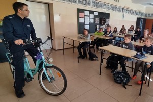 Na zdjęciu widzimy policjanta siedzącego na rowerze w czasie profilaktyki