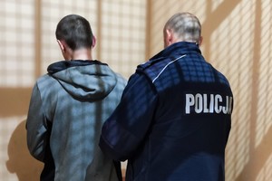 Na zdjęciu widzimy zatrzymanego oraz policjanta