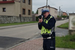 Na zdjęciu widzimy policjanta w czasie mierzenia prędkości