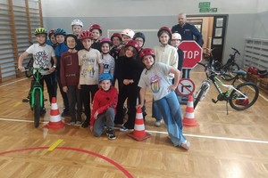Na zdjęciu widzimy policjanta oraz uczniów po egzaminie na kartę rowerową