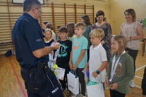 Na zdjęciu widzimy uczestników turnieju oraz policjanta