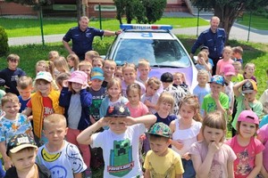 Na zdjęciu widzimy dzieci z przedszkola oraz dzielnicowych oraz radiowóz
