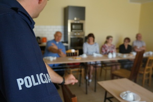 Na zdjęciu widzimy napis policja oraz w tyle seniorów