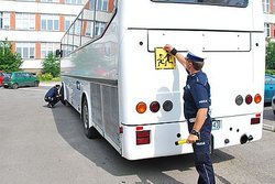 Na zdjęciu widzimy autobus oraz policjanta