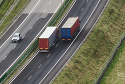 Na zdjęciu widzimy dwa samochody ciężarowe jadące obok siebie