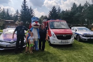 Na zdjęciu widzimy policjantów, radiowóz oraz maskotkę śląskiej policji Sznupka