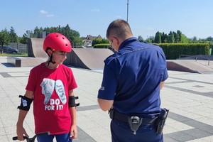 Na zdjęciu widzimy policjanta oraz chłopca