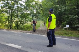 Na zdjęciu widzimy policjanta oraz uczestników Bieruńskiego Pucharu MTB