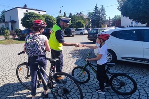 Na zdjęciu widzimy policjanta rozmawiającego o bezpiecznej drodze do szkoły