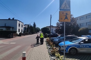 Na zdjęciu widzimy policjanta rozmawiającego o bezpiecznej drodze do szkoły