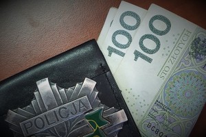 Na zdjęciu widzimy odznakę policyjną oraz pieniądze