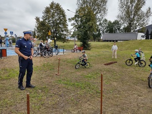 Na zdjęciu widzimy rowerowy tor przeszkód oraz policjanta