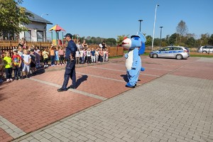 Na zdjęciu widzimy policjanta oraz sznupka wraz z grupą dzieci z przedszkola