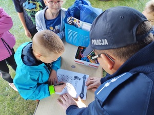 Na zdjęciu widzimy policjanta oraz uczestników rajdu rowerowego