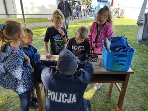 Na zdjęciu widzimy policjanta oraz uczestników rajdu rowerowego