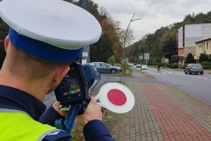 Na zdjęciu widzimy policjanta mierzącego prędkość w rejonie przejścia dla pieszych