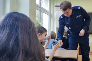 Na zdjęciu widzimy policjanta w czasie omawiania cyberbezpieczeństwa