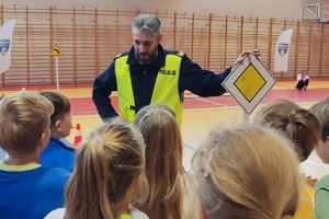 Na zdjęciu widzimy policjanta w czasie omawiania przepisów ruchu drogowego