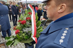 Na zdjęciu widzimy policjanta z wieńcem