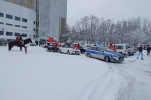 Na zdjęciu widzimy radiowóz oraz uczestników MotoMikołaje