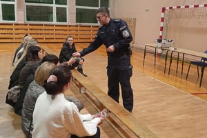 Na zdjęciu widzimy policjanta w czasie profilaktyki z rodzicami