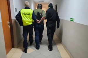 Na zdjęciu widzimy zatrzymanego oraz policjantów