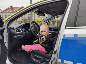 Na zdjęciu widzimy dziecko siedzące w radiowozie