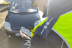 Na zdjęciu widzimy policjanta sprawdzającego pojazd