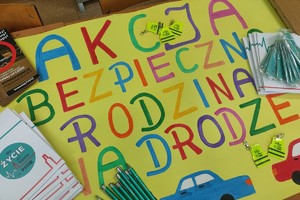 Na zdjęciu widzimy napis Akcja Bezpieczna Rodzina na drodze oraz gadżety, które otrzymywali kierujący