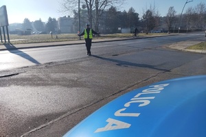 Na zdjęciu widzimy policjanta w czasie zatrzymywania pojazdu do kontroli