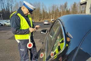 Na zdjęciu widzimy policjanta sprawdzającego pojazd