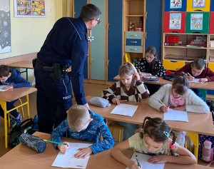 Na zdjęciu widzimy policjanta w czasie pogadanki z dziećmi