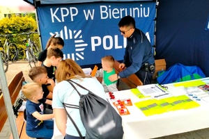 Na zdjęciu widzimy policjanta oraz uczestników rajdu