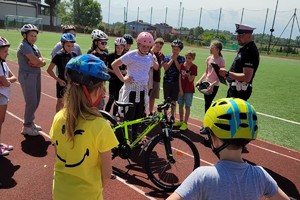 Na zdjęciu widzimy policjanta oraz uczniów w czasie egzaminu na kartę rowerową