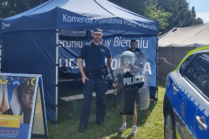 Na zdjęciu widzimy policjantów oraz dziecko w czasie festynu