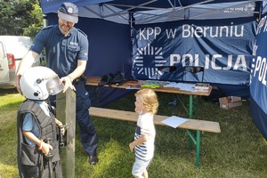 Na zdjęciu widzimy dzieci oraz policjanta w czasie festynu