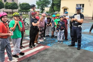 Na zdjęciu widzimy uczniów oraz policjanta w czasie egzaminu na kartę rowerową