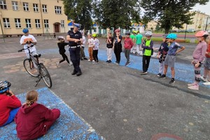 Na zdjęciu widzimy uczniów oraz policjanta w czasie egzaminu na kartę rowerową