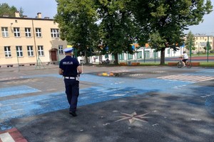 Na zdjęciu widzimy uczniów oraz policjanta w czasie egzaminu na kartę rowerową