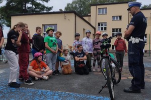 Na zdjęciu widzimy uczniów oraz policjanta w czasie egzaminu na kartę rowerową