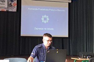 Na zdjęciu widzimy policjanta prowadzącego debatę