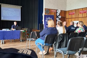 Na zdjęciu widzimy policjanta prowadzącego debatę oraz uczestników