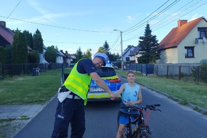 Na zdjęciu widzimy policjanta wraz z chłopcem