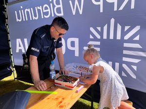 Na zdjęciu widzimy policjanta oraz dziecko