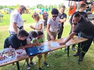 Na zdjęciu widzimy uczestników festynu oraz policjanta