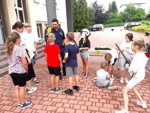 Na zdjęciu widzimy policjantów oraz uczestników półkolonii